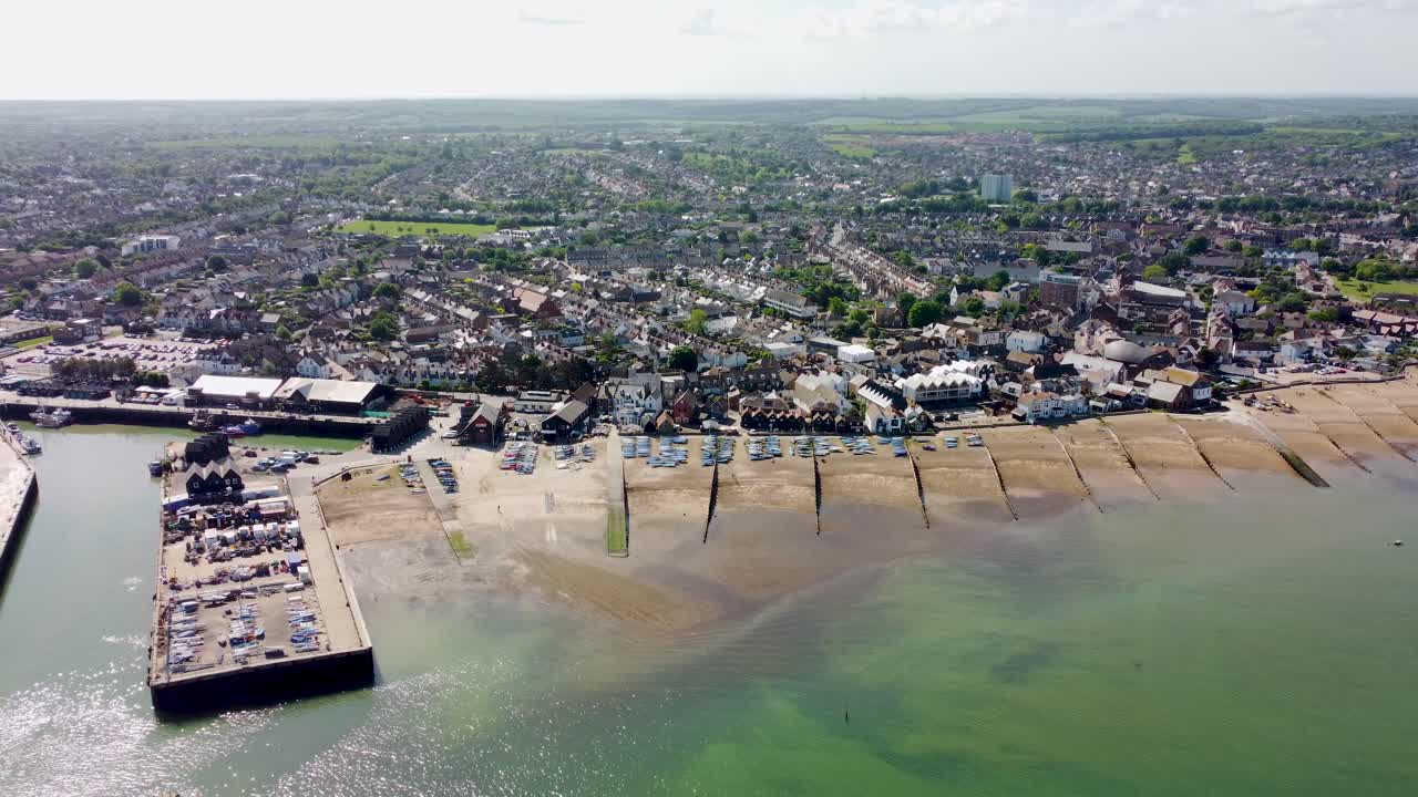 una panorámica aérea lenta de la playa y el puerto de whitstable
