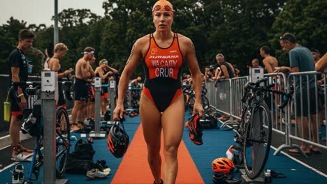 female athlete preparing for triathlon event, focused and determined, amidst competitive atmosphere with bicycles and other participants in background