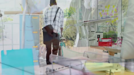 Animation-of-male-and-female-colleague-using-laptops-over-man-arriving-at-creative-office-on-bike