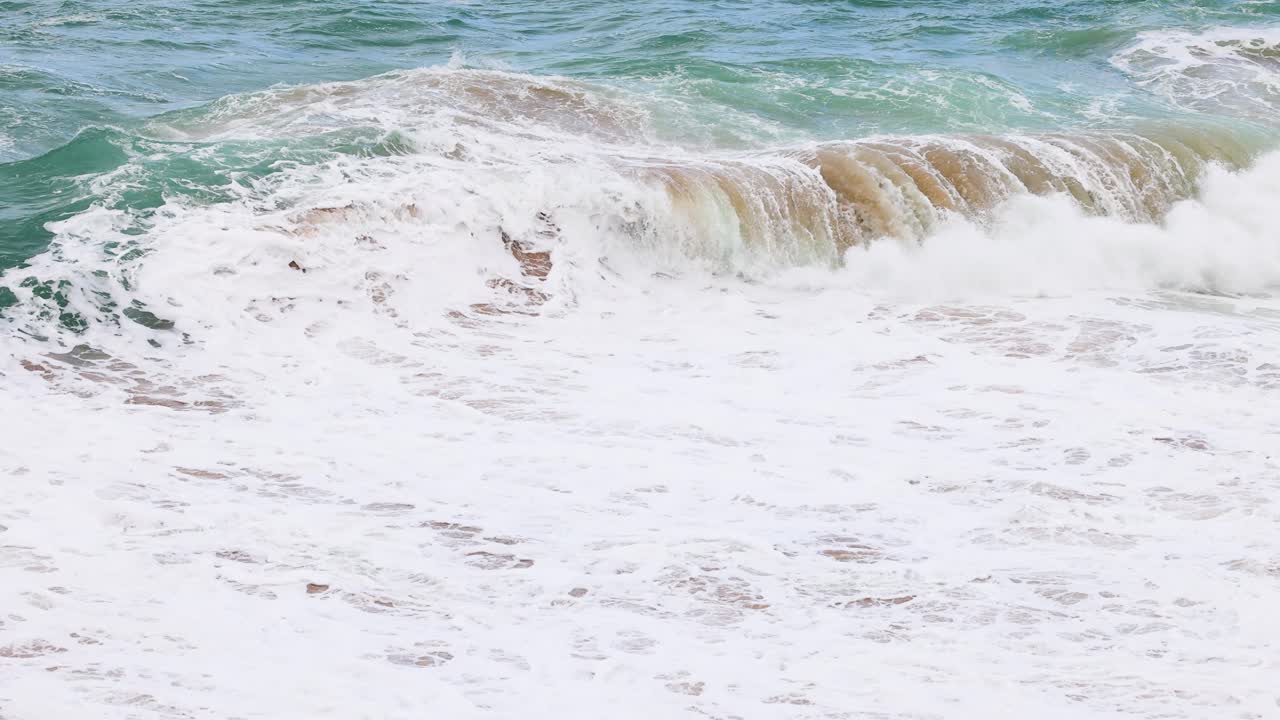 Dynamic ocean waves crash against the shore at Port Campbell, Australia, captured in bright daylight with a focus on natural movement
