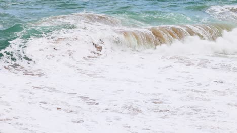 dynamic ocean waves crash against the shore at port campbell, australia, captured in bright daylight with a focus on natural movement