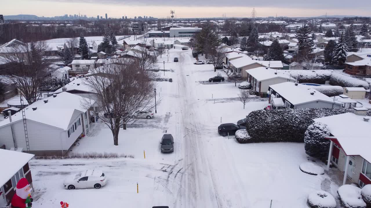Suburban neighborhood covered in snow with local houses and a distant village skyline, Saint-Constant, Quebec, Canada.