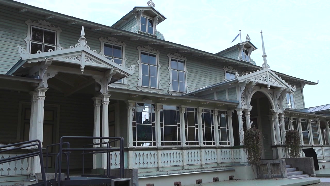 Immagini di un'idilliaca vecchia casa in legno, sala riunioni nella città turistica costiera di Haapsalu, Estonia. Casa a scandole con pilastri bianchi, colonne e disegni a graticcio in legno e ornamenti in pizzo di legno
