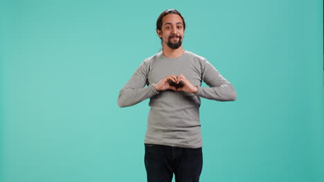 persona sonriente mostrando un símbolo de forma de corazón gesto con las manos