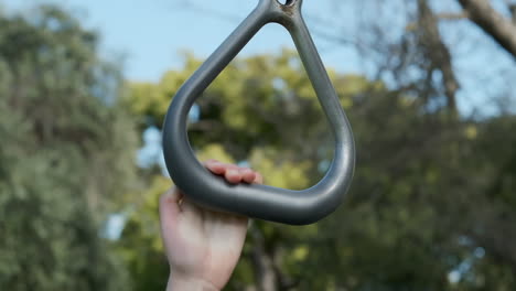 slow motion close-up of a child's hand holding onto a gymnastics ring and then letting go