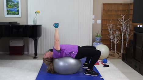 woman performing bench press with twist on exercise ball, static locked off