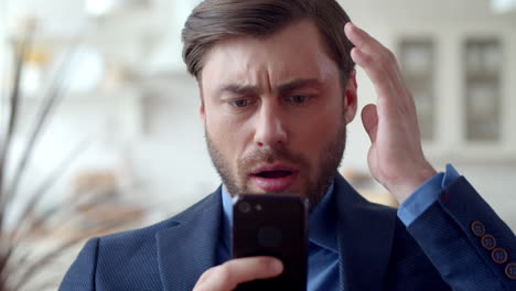 shocked business man reading sad news on cellphone