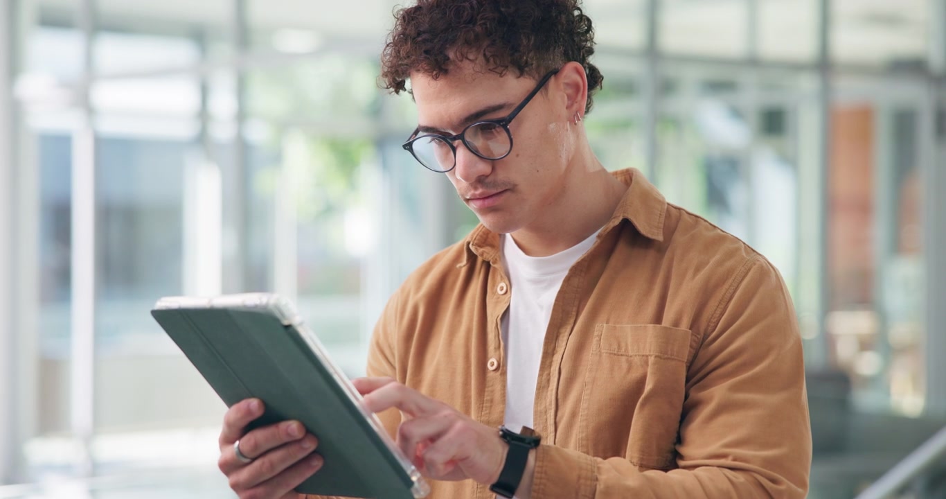 Young Man Using a Digital Tablet in a Modern Office