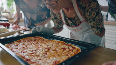 elderly woman and grandchildren enjoying smell of freshly baked pizza