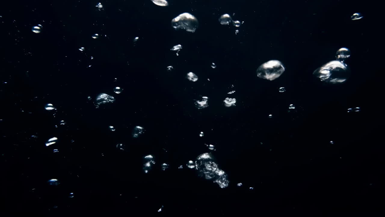 Rising Underwater Bubbles Ascend Through Inkblack Water With Gentle Buoyancy And Scattered Reflections