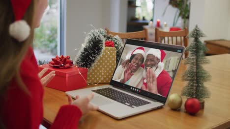 Glückliche-Kaukasische-Frau-Bei-Einem-Videoanruf-Mit-Einem-älteren-Paar-Zur-Weihnachtszeit