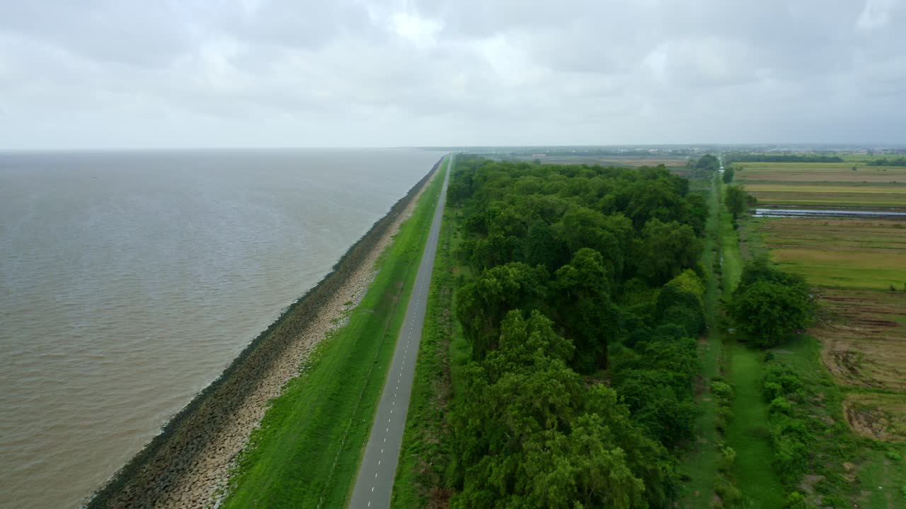 Aerial: Sea dyke view along the road, small jungle, North Atlantic Ocean and Nickerie Suriname