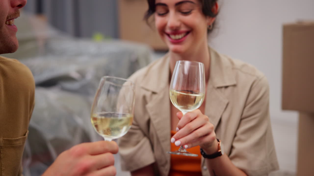 Coppia felice che brinda con calici di vino nella nuova casa