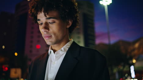 un hombre de negocios feliz caminando por la ciudad de la noche. un joven relajado moviéndose con calma.