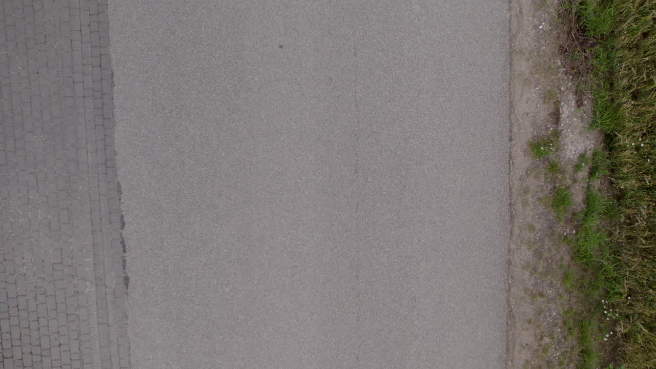 레이싱 자전거를 타고 아스팔트 도로를 슬로우 모션으로 달리는 사람을 보여주는  ⁇  뷰