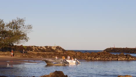 small boat navigating near brunswick heads beach