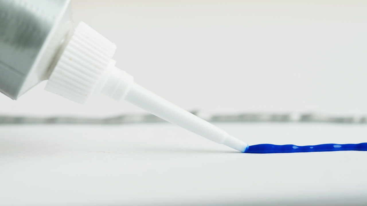 Gel blu erogato da un tubetto su una superficie bianca