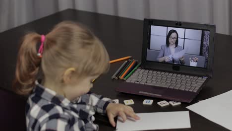 girl distance education lesson with woman teacher, using digital laptop at home