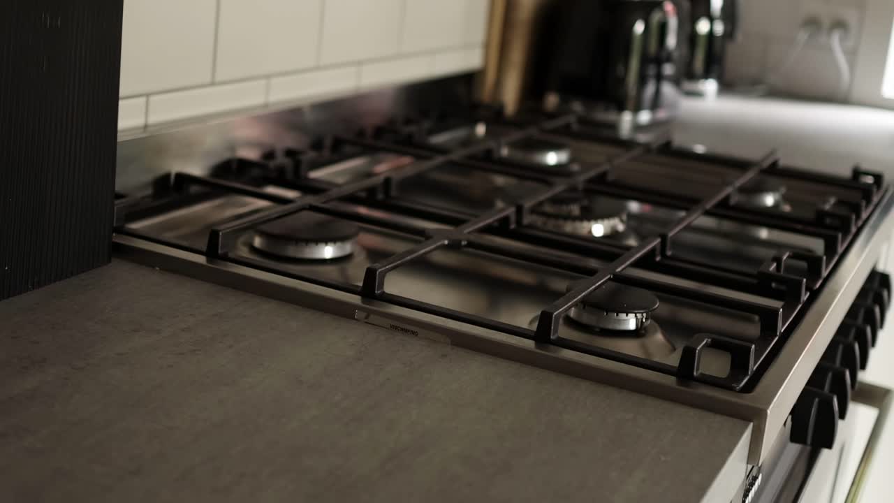Detailed view of stainless steel gas stove burners and controls in a contemporary kitchen setting.