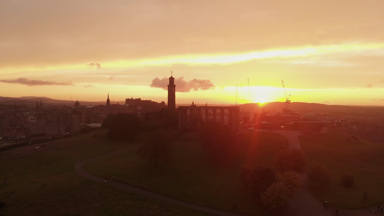 Aerial view of beautiful Edinburgh Scotland during dramatic sunset- Drone view lowering on Calton Hill