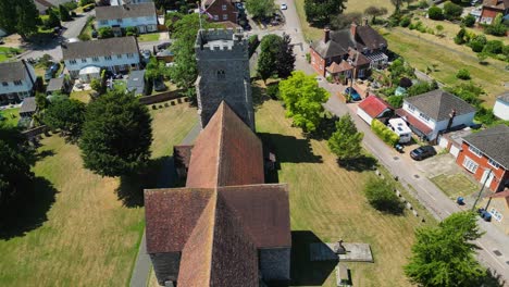 an angled push-in shot of st mary's church in chartham, pushing in towards the tower flying the union flag