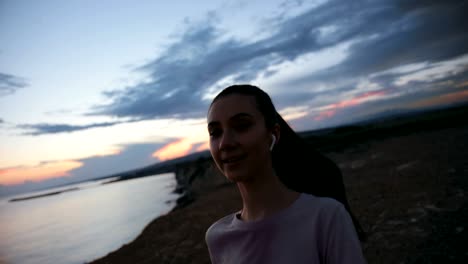 young woman jogging on sea cliff and giving high five