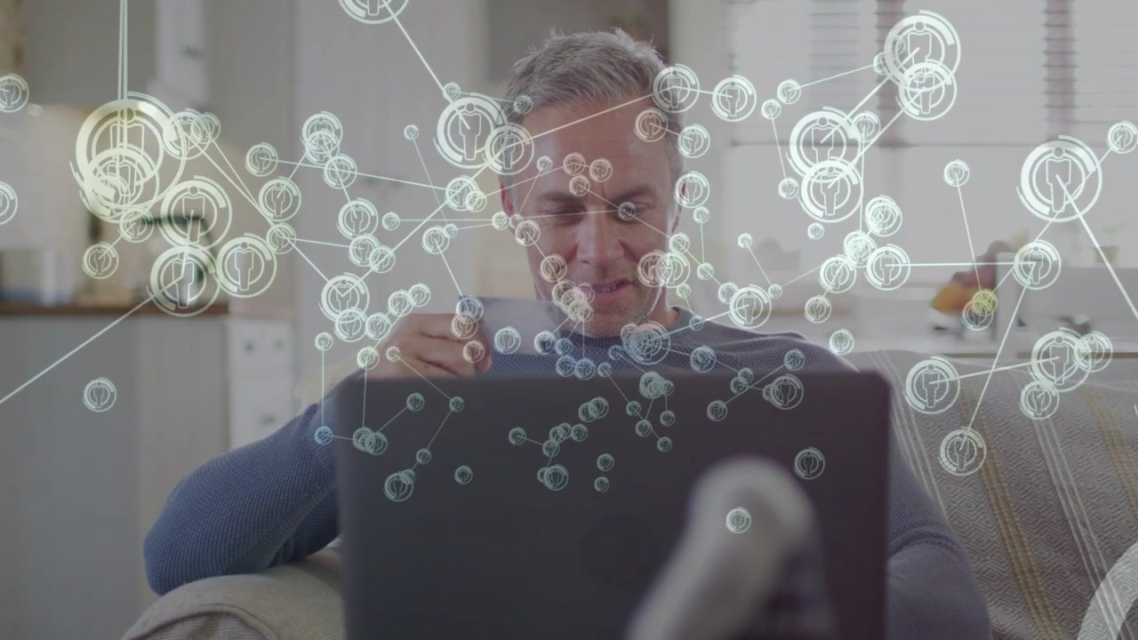 Uomo che sorseggia da una tazza mentre lavora al laptop, con nodi tecnologici che crescono e avviano l'interazione, oscurando l'uomo.