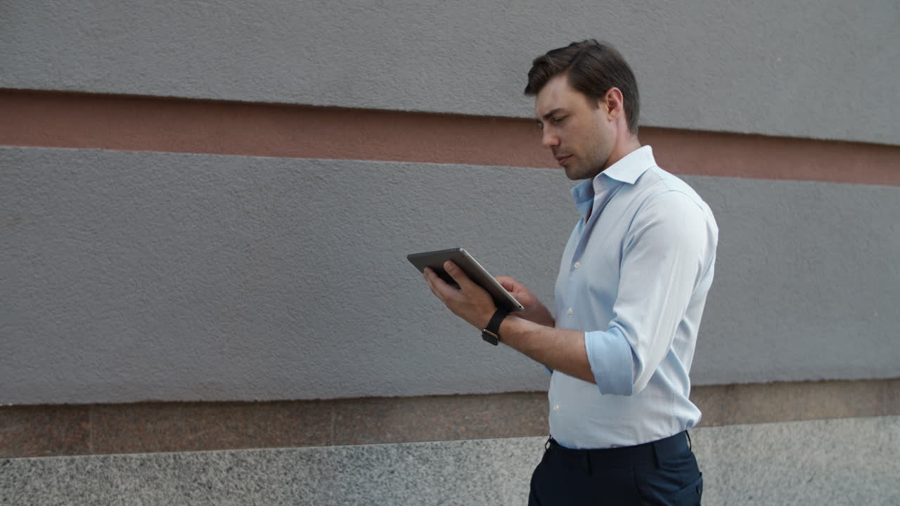 Close up view of businessman walking with tablet