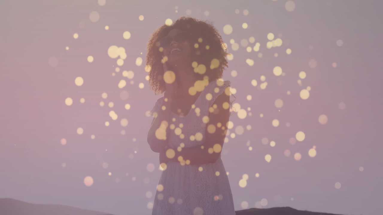 woman standing on hilltop at dusk, showcasing health app concept with floating golden lights
