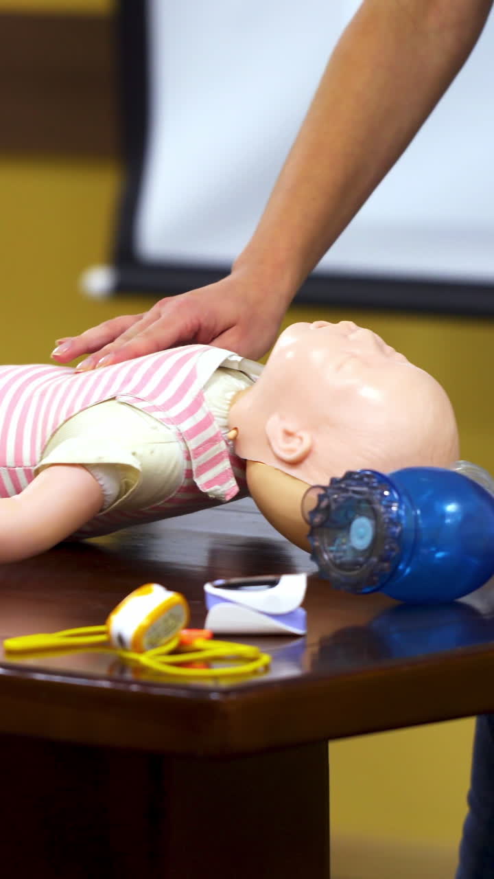 Baby first aid training. First aid training to giving cardiopulmonary resuscitation to child. Vertical video