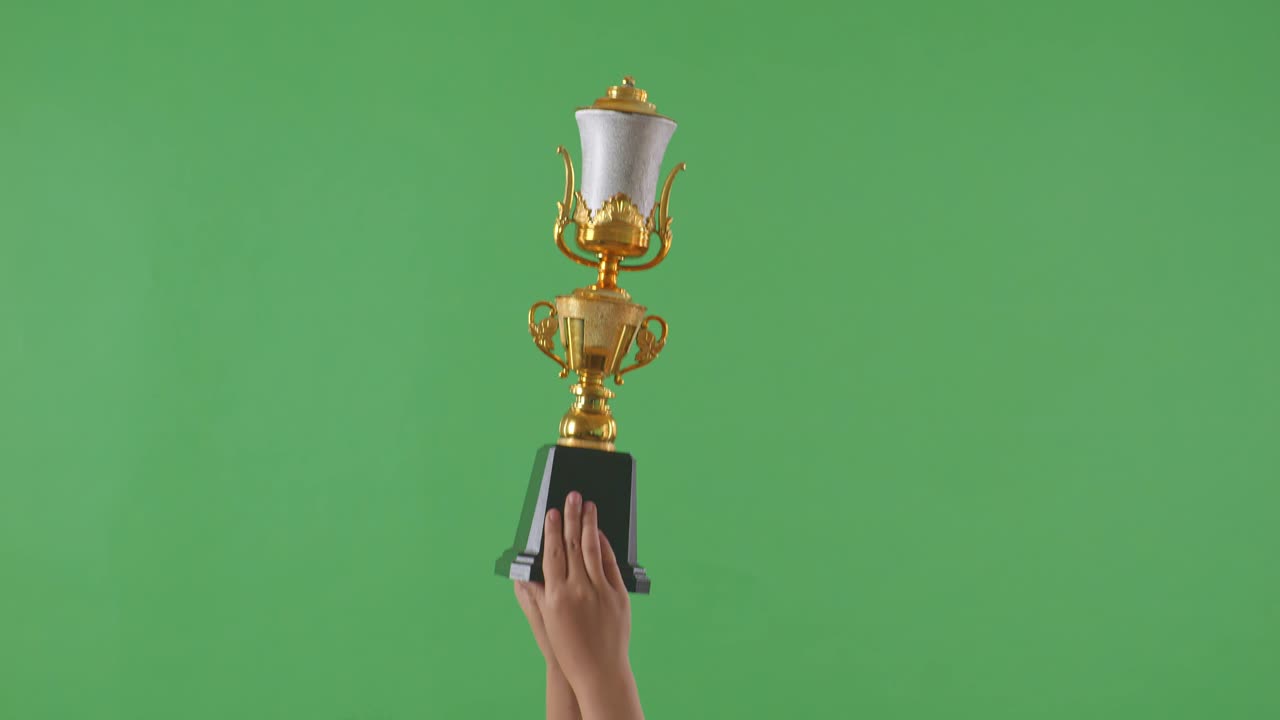 las manos levantadas de una mujer están sosteniendo un trofeo. fondo de pantalla verde