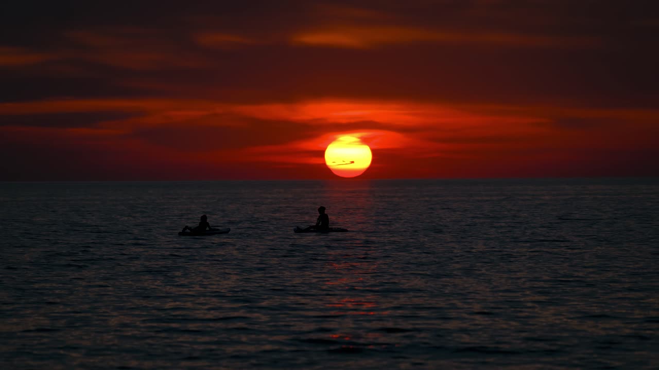 Peaceful sunset in Istria Croatia with silhouettes of stand up paddlers gliding across the sea