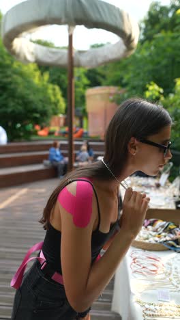 woman browsing jewelry at an outdoor market