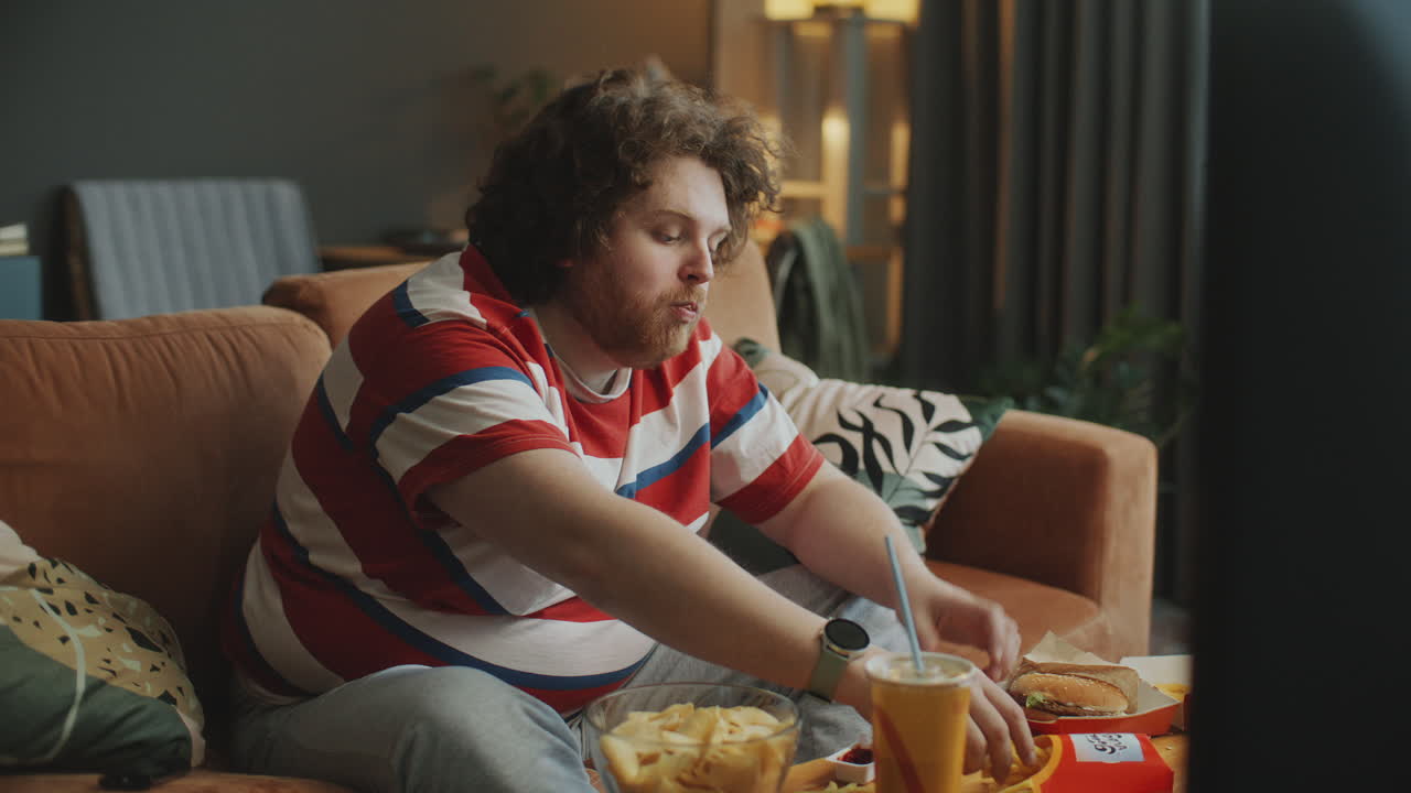 Man Eating Fast Food While Watching TV