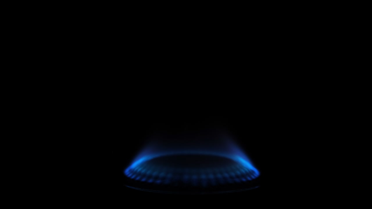 검은 바탕에 고립 된 가스 스토브를 켜고 있습니다. 천연 가스 적자 개념. 4k 해상도 비디오