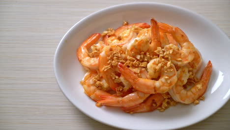 fried shrimps or prawns with garlic on white plate - seafood style