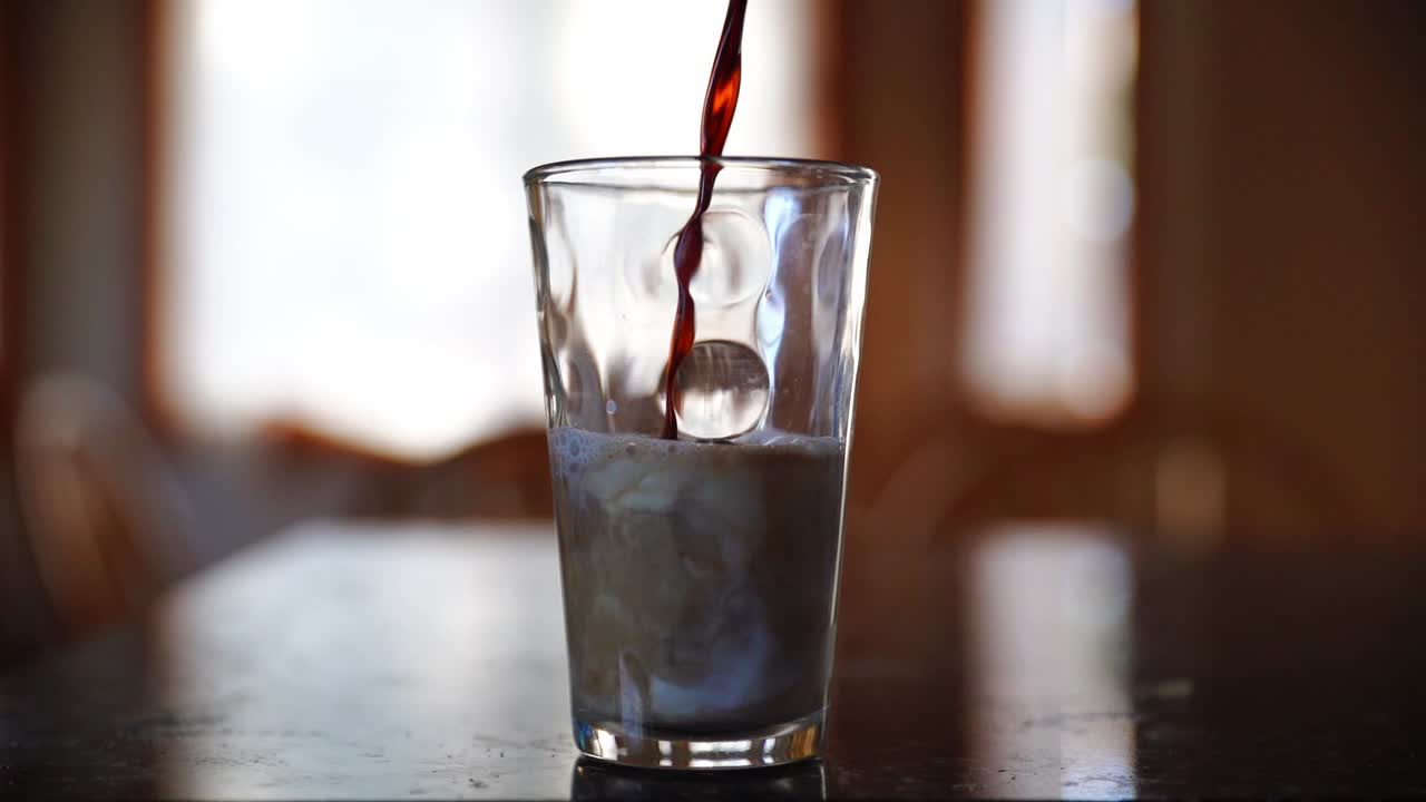 느린 동작으로 우유 위에 커피를 부었습니다.