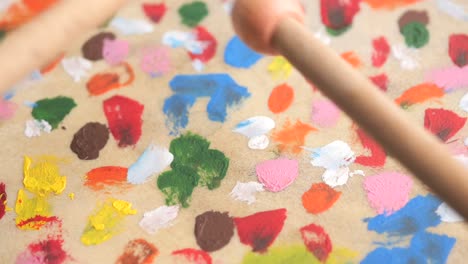 colorful paint-covered drum with drumsticks