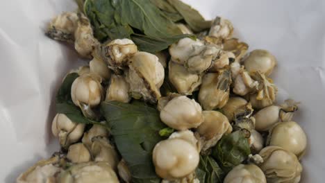 ostra al vapor con hojas de albahaca lista para servir en el mercado de pescado de tailandia