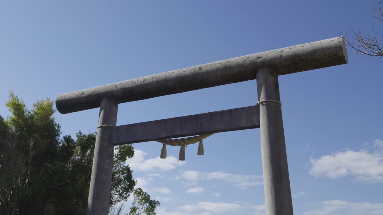 Lindo portal Torii de pedra com céu azul ao fundo, plano de câmera de slider médio