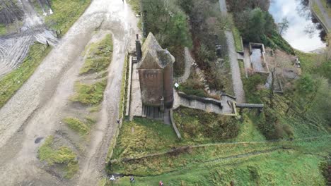 Historic-creepy-fairy-tale-Rivington-pigeon-tower-aerial-birdseye-orbit-left-view-overlooking-English-Winter-hill-farming-countryside