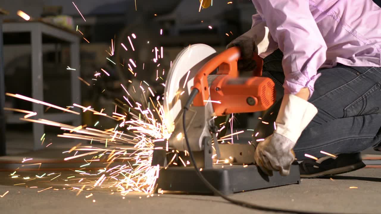 hombre trabajó duro y aserrar acero. trabajador que utiliza cortador de metal circular tiene chispa de iluminación. concepto de ingeniería, taller, industria, fabricación y negocios.