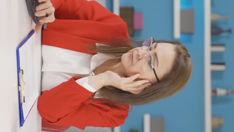 Vertical-video-of-Home-office-worker-woman-is-tired-and-sleepy.