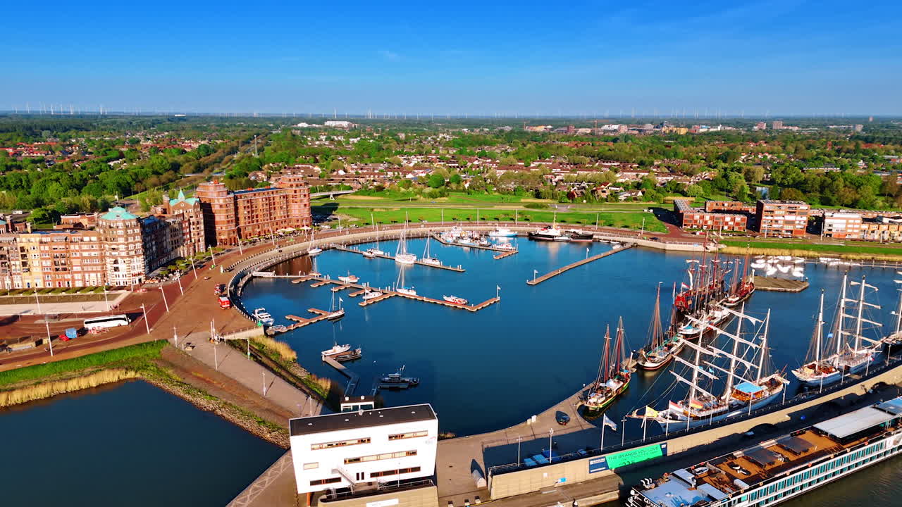Approaching the port of picturesque Lelystad, the Netherlands on the lake Markermeer. Old ships and modern yachts stand at the berths. Aerial view.