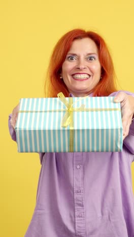 woman with red hair smiling and presenting a gift