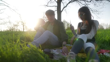 couple playing cards in a park at sunset