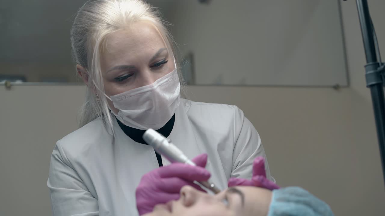 Kosmetologisk specialist justerer hvid maske i skønhedssalon