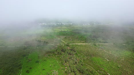 Dramatic drone movement after the Virgin Island Beach on misty rural Crozon peninsula landscape with faint hiking paths, Brittany, France
