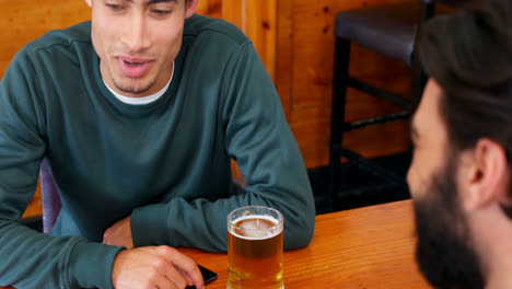 Freunde-Interagieren-Beim-Biertrinken-Am-Tisch-4k