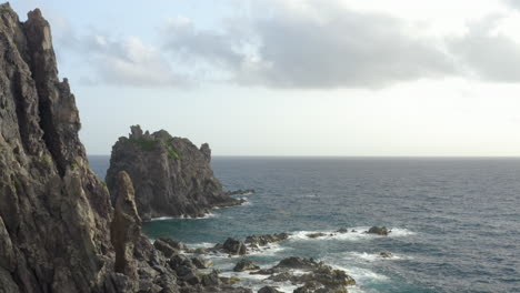 abandoned caribbean beach in the early morning. smooth fly in pass a jagged cliffside to reveal large rocks in the blue ocean.
4k uhd at 23.98 fps.